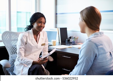 Doctor In Consultation With Female Patient In Office