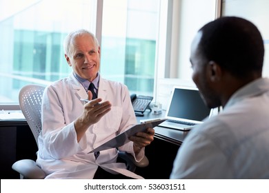 Doctor In Consultation With Male Patient In Office