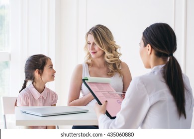 Doctor Consulting Family Pregnant Mother With Daughter In A Hospital.