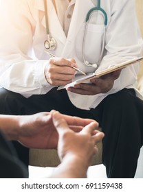 Doctor Consulting Male Patient, Working On Diagnostic Examination On Men's Health Disease Or Mental Illness, While Writing On Prescription Record Information Document In Clinic Or Hospital Office