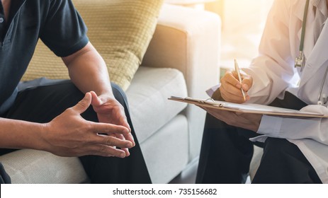 Doctor consulting male patient, working on diagnostic examination on men's health disease or mental illness, while writing on prescription record information document in clinic or hospital office