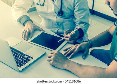 Doctor Is Consulting With Patient About His Health On Working Desk Which Using Technology Tablet At Hospital, Physician Concept