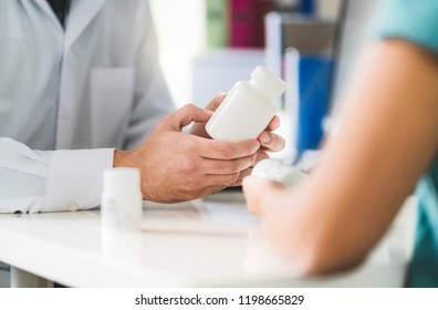 Doctor Consulting Patient About Right Medication. Physician Holding Medicine And Pills In Hand. Pharmacist In Pharmacy In Customer Service. Pain Killers, Antidepressants Or Prescription Drugs.