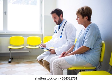 Doctor Consulting Patient In Hospital Waiting Room