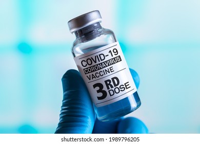 doctor with Coronavirus vaccine bottle with the name of the Third vaccine on the label. COVID-19 Vaccine Vial for vaccination tagged with 3rd dose - Shutterstock ID 1989796205
