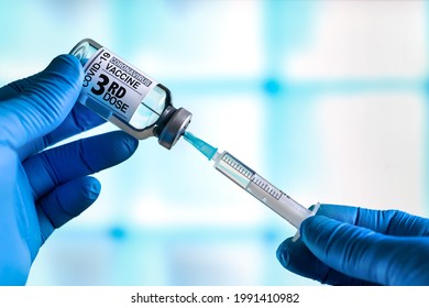 doctor with Coronavirus vaccine bottle with the name of the 3rd dose of vaccine on the label. Doctor preparing a dose for a patient of the third vaccine for Covid-19 - Shutterstock ID 1991410982