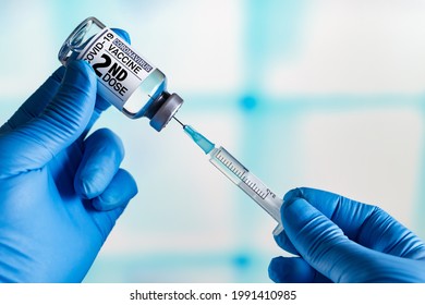 Doctor with Coronavirus vaccine bottle with the name of the 2nd dose of vaccine on the label. Doctor preparing a dose for a patient of the second vaccine for Covid-19 - Shutterstock ID 1991410985