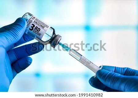 doctor with Coronavirus vaccine bottle with the name of the 3rd dose of vaccine on the label. Doctor preparing a dose for a patient of the third vaccine for Covid-19