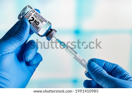 Doctor with Coronavirus vaccine bottle with the name of the 2nd dose of vaccine on the label. Doctor preparing a dose for a patient of the second vaccine for Covid-19
