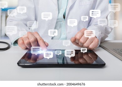 The doctor is in correspondence with messages on a tablet on a blurred background. - Shutterstock ID 2004649676