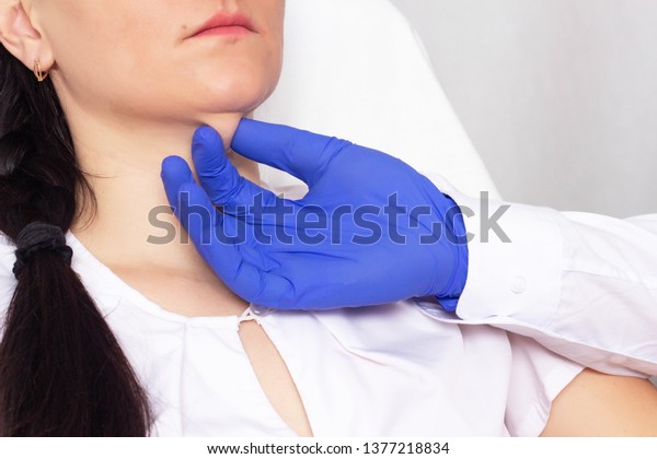 Doctor\
cosmetologist checks the skin for elasticity on a double chin in a\
girl, close-up, cosmetology,\
resilience