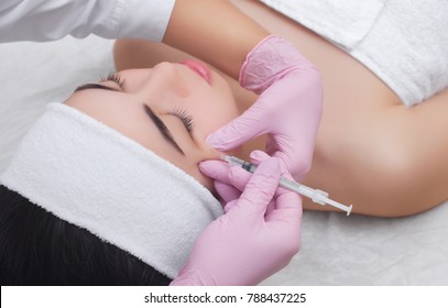 The doctor cosmetologist makes the Botulinum Toxin injection procedure for tightening and smoothing wrinkles on the face skin of a beautiful, young woman in a beauty salon.Cosmetology skin care. - Shutterstock ID 788437225
