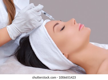 The doctor cosmetologist makes the Rejuvenating facial injections procedure for tightening and smoothing wrinkles on the face skin of a beautiful, young woman in a beauty salon.Cosmetology skin care. - Shutterstock ID 1006651423