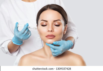 The doctor cosmetologist makes the Rejuvenating facial injections procedure for tightening and smoothing wrinkles on the face skin of a beautiful, young woman in a beauty salon.Cosmetology skin care. - Shutterstock ID 1309337428