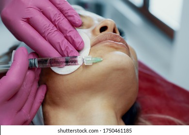 The doctor cosmetologist makes the Rejuvenating facial injections procedure for tightening and smoothing wrinkles on the face skin of a beautiful, young woman in beauty salon.Cosmetology skin care