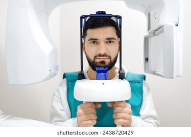 Doctor dentist are going to do a digital x-ray with man patient in dentistry clinic. Panoramic radiography. Modern professional dental equipment for hospital, clinic, medical center. - Powered by Shutterstock