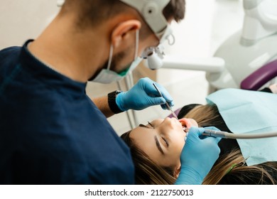 Doctor Dentist Treats The Teeth Of A Patient Under A Microscope