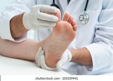 Doctor dermatologist examines the foot on the presence of athlete's foot - Powered by Shutterstock