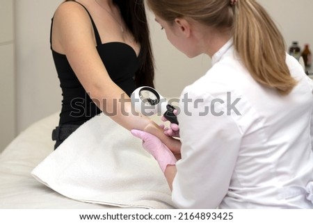 Doctor dermatologist examines skin of patient. Dermatoscopy, prevention of melanoma, skin cancer.