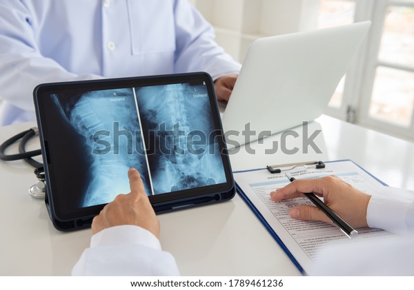 doctor diagnose spine lumber vertebrae x-ray image\
on digital tablet for diagnose Herniated disc disease with\
radiologic technologist\
team.