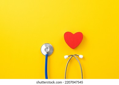 Doctor diagnoses and care design concept - stethoscope with red heart on yellow background.