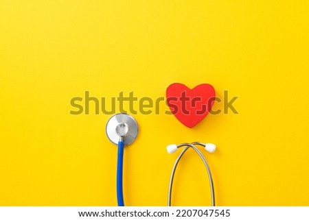 Doctor diagnoses and care design concept - stethoscope with red heart on yellow background.