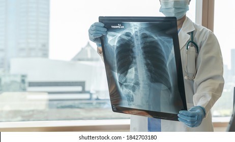 Doctor Diagnosing Patient’s Health On Asthma, Lung Disease, COVID-19 Or Bone Cancer Illness With Radiological Chest X-ray Film For Medical Healthcare Hospital Service