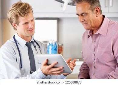 Doctor Discussing Records With Patient Using Digital Tablet