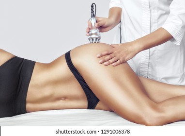 The doctor does the Rf lifting procedure on the legs, buttocks and hips of a woman in a beauty parlor. Treatment of overweight and flabby skin.