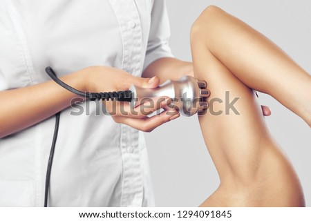 The doctor does the Rf lifting procedure on the upper arm of a woman in a beauty parlor. Treatment of overweight and flabby skin.