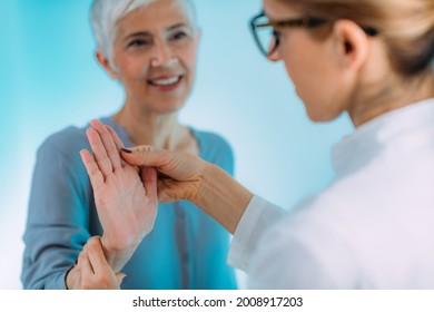 Doctor Doing Carpal Tunnel Syndrome Test With A Senior Woman.