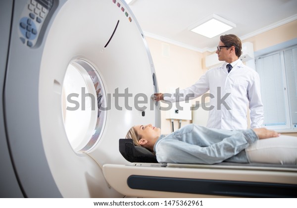 Doctor doing computed tomography for\
female patient stock photo. Medicine diagnostic\
concept