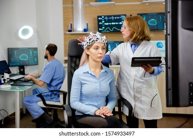 Doctor Doing A Girl's Brain Scan Procedure In A Scientific Lab. Modern Equipment