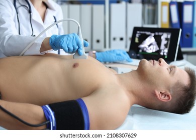 Doctor Doing Heart Ultrasound To Young Male Patient In Clinic