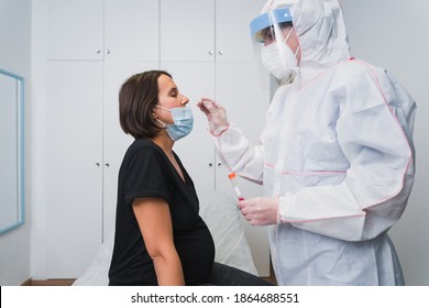 A doctor doing a PCR to detect Covid 19 on a pregnant woman in the doctor's office to avoid the risk of contagion.