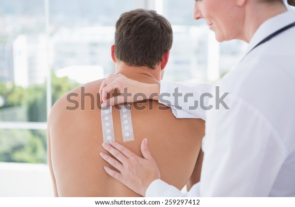 Doctor\
doing skin test to her patient in medical\
office