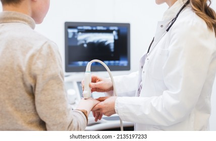 Doctor Doing Ultrasonic Scan On Hand Of Boy