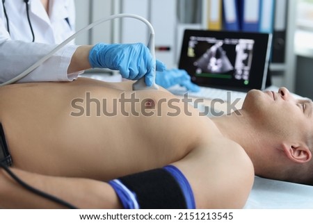 Doctor doing ultrasound of rib cage, cardiologist examining a patients heart