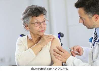 Doctor Doing Vaccine Injection To Elderly Woman