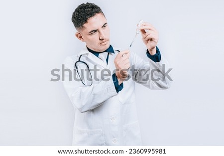 Doctor drawing antidote from a vial. Concept of doctor with disease antidote. Handsome doctor drawing medicine from a vial with copy space