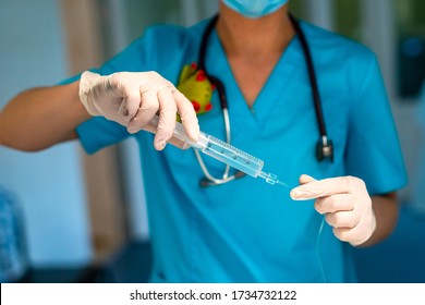 A doctor draws a medicine into a syringe. Disease treatment. Drugs against infectious diseases. Hands in gloves hold a dropper. Concept - treatment with medications - Shutterstock ID 1734732122