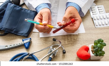 Doctor during consultation held in his hand and shows patient laboratory tube with blood. Counseling of transfusion, blood and hematologic diseases and pathology like anemias, cell cancer, hemophilia