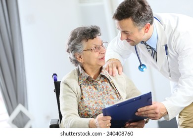 Doctor With Elderly Woman In Nursing Home