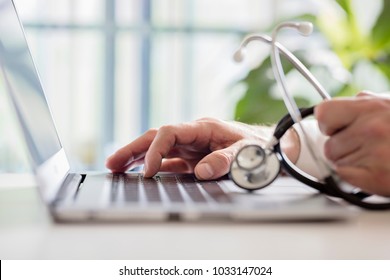 Doctor entering patient notes on a laptop in surgery