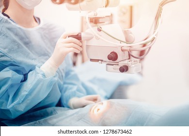 Doctor Examines Fundus In Microscope, Patient Under Sterile Cover. Laser Vision Correction Lasik.