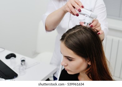 Doctor Examines The Hairy Part Of The Patient's Head - Pretty Young Girl. Trihoskopiya, Psoriasis, Dandruff, Split Ends, Peeling, Dermatology.