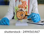 Doctor examines model of digestive system using magnifying glass. Overview of methods for diagnosing intestinal and gastric diseases