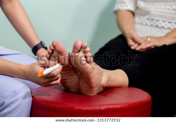The doctor examines the nerve response with\
monofilament odiatrist treating feet during procedure. Doctor\
neurologist examining female patient\
.