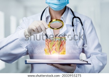 Doctor examines skin model with magnifier on blurred background.