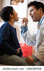 Doctor Examining Boy's Throat With Tongue Depressor.